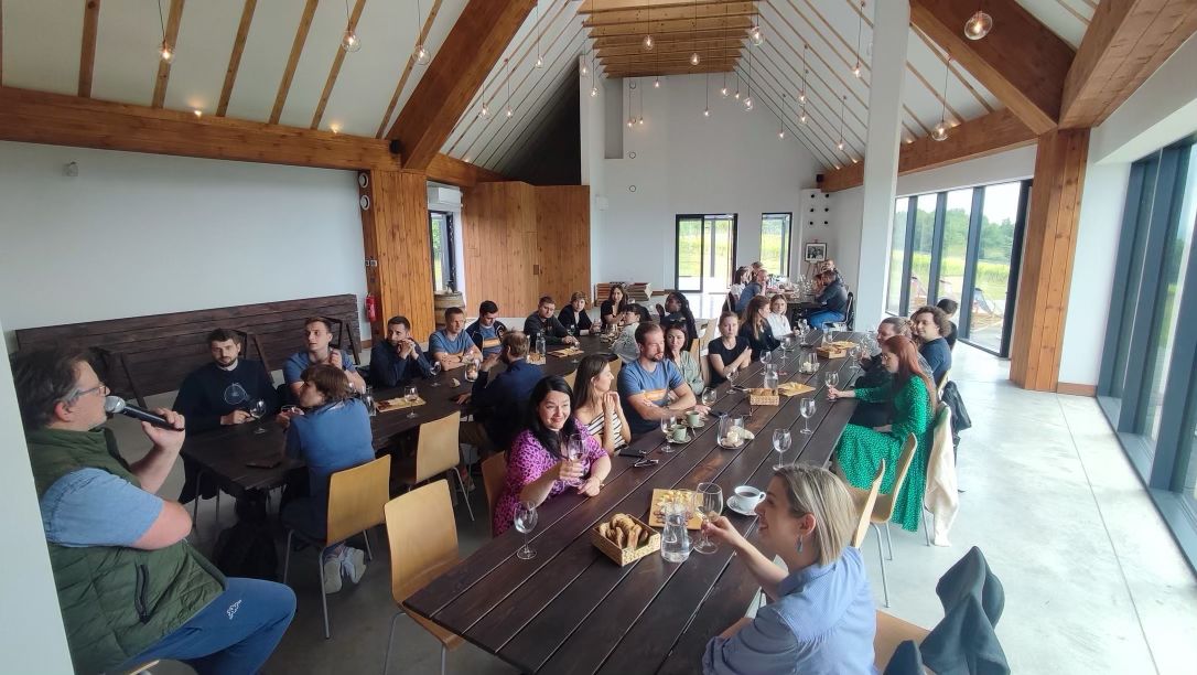 Host presenting to a seated group at a long table during a company trip — FORTravels DMC Poland