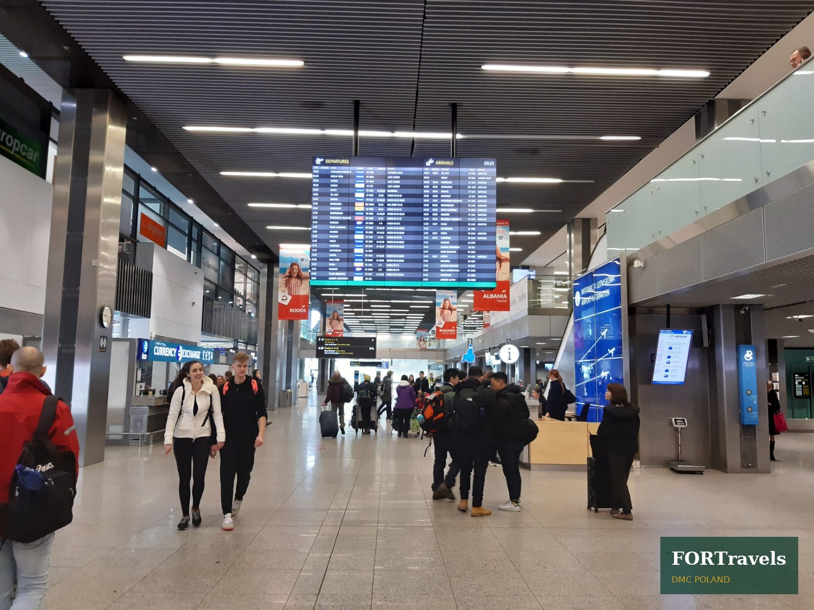 Hala przylotów lotniska w Krakowie z tablicą odlotów i przylotów – FORTravels DMC Poland