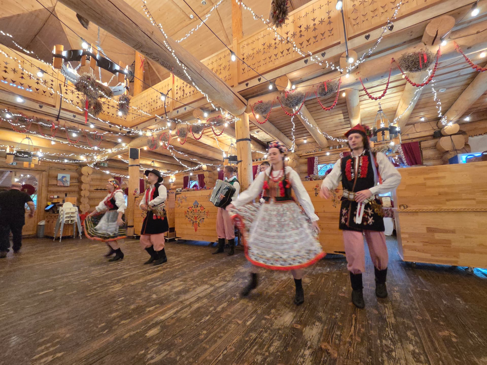 Polish folk dancers in Kraków costumes spinning in a wooden highland hall — FORTravels DMC Poland